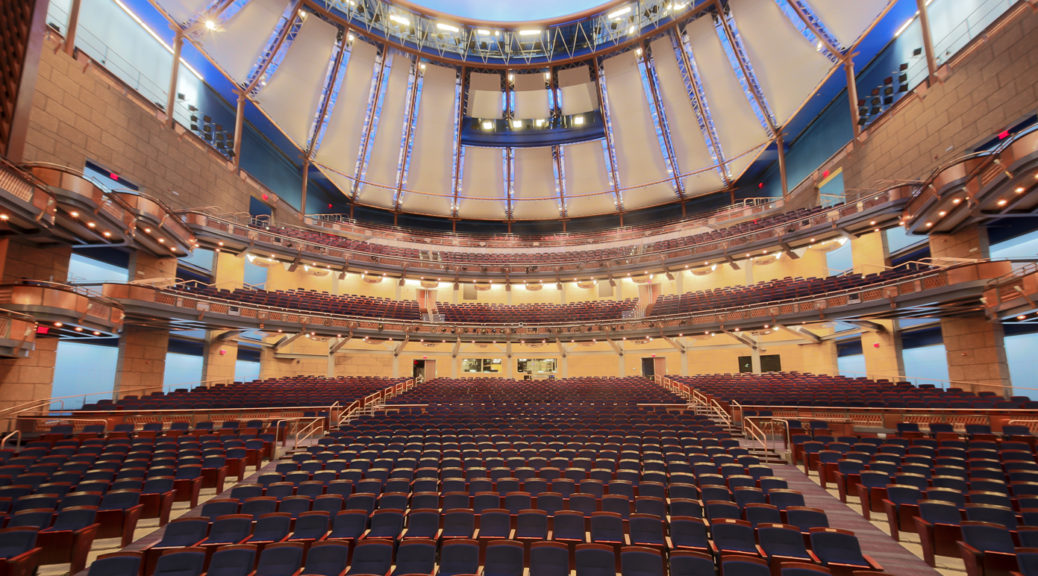 Interior view of an empty ornate theater with a large dome ceiling.